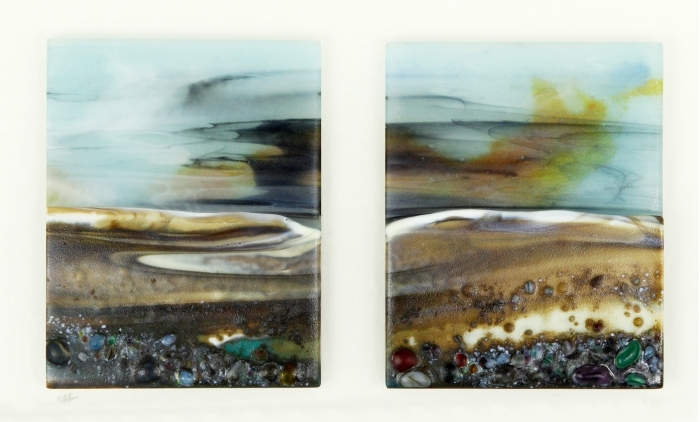 Glass Wall Art, landscape diptych with calm pale blue sky and low sunset, landscape teal/browns/vanilla headland with a mix of coloured glass frits in foreground.