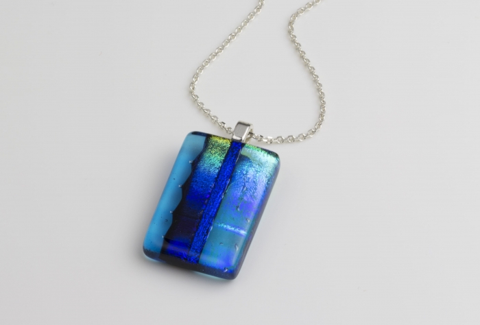 Close-up of coloured glass necklace in shades of blue and green