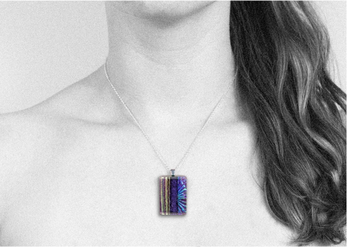 Handmade glass pendant necklace with a clear violet base and a mix of subtle dichroic starburst and textured lines, divided by bold violet dichroic. Sterling silver 16-18" chain.
