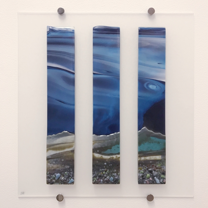 Glass Wall Art, coastal landscape triptych with moody blue sky clouds art, landscape greens and cream with glass frits in foreground.